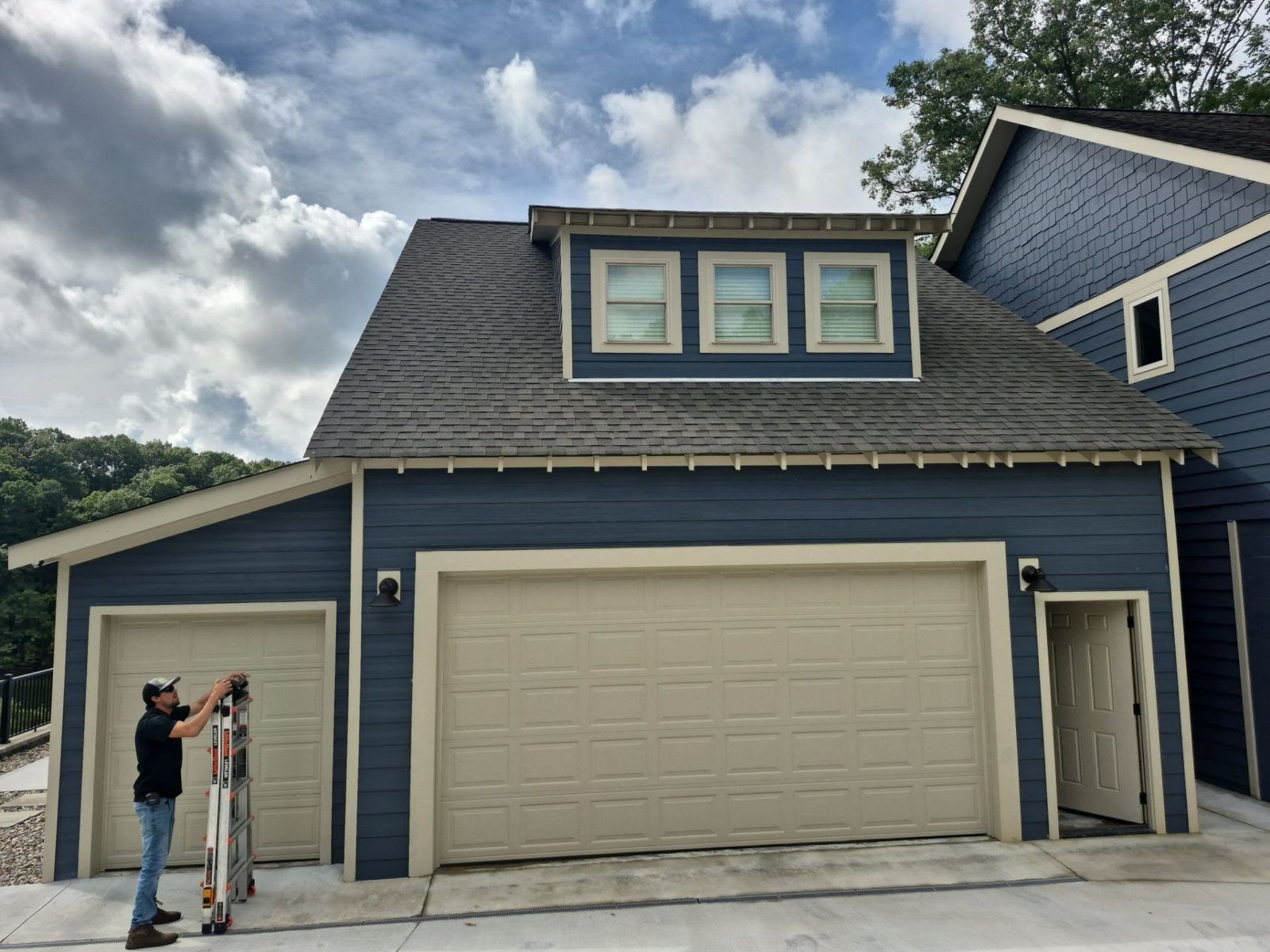 Two-story blue home with a finished roof by M&G Roofing