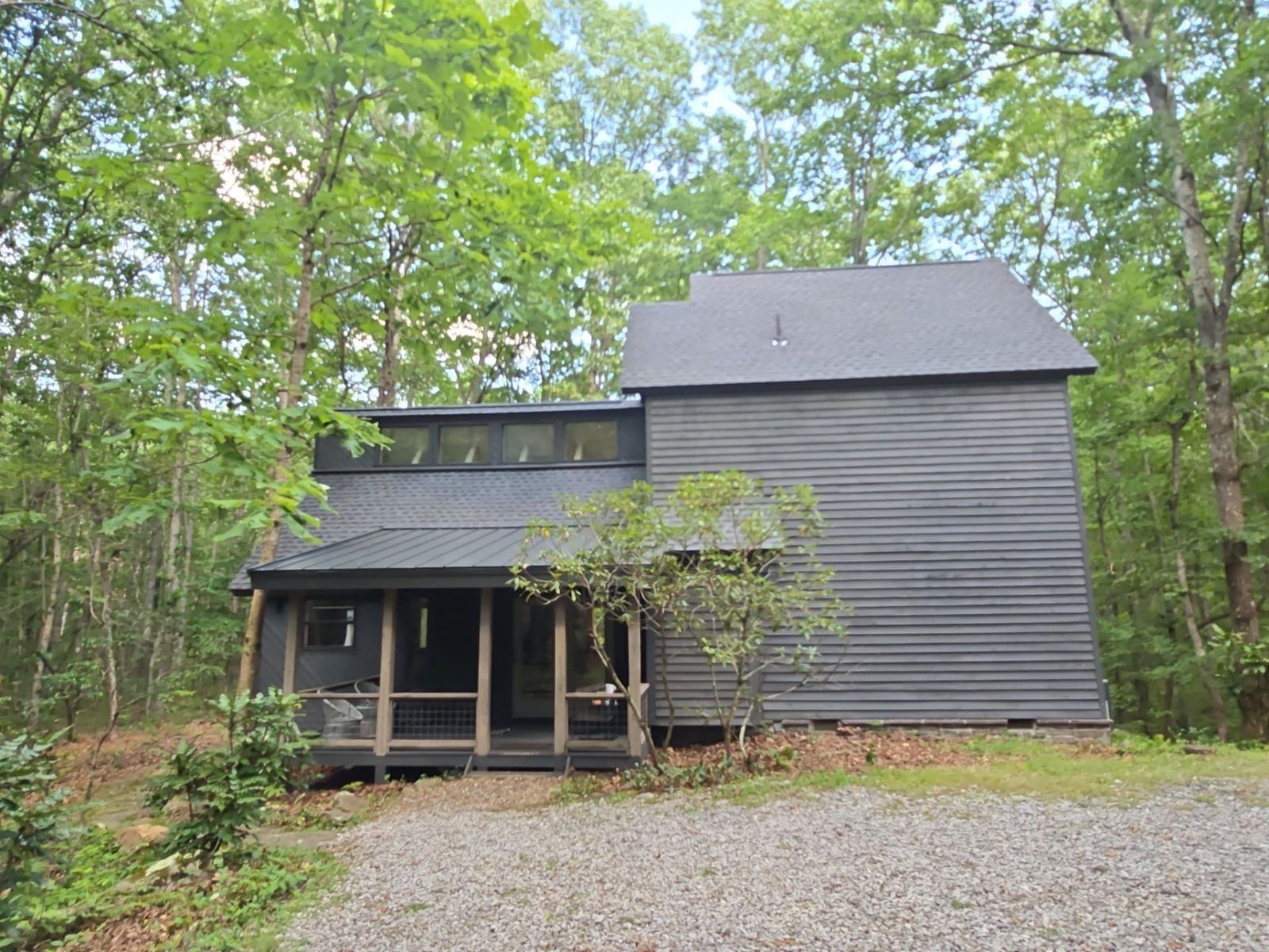 Two-story home with a finished roof among trees